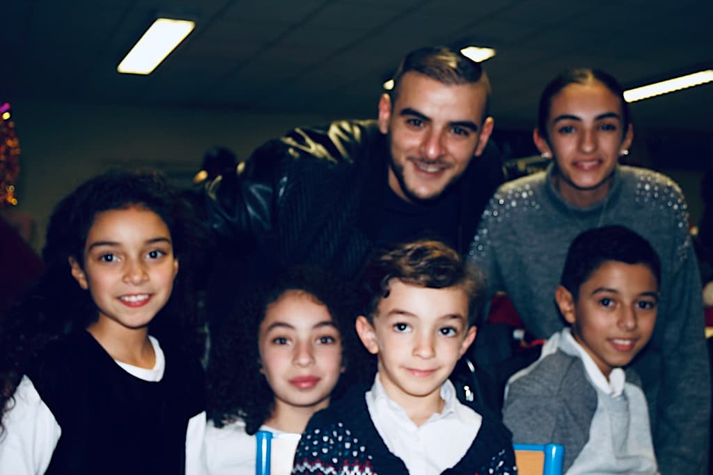 Vis et Deviens - L'artiste Sofiane qui pose avec des enfants