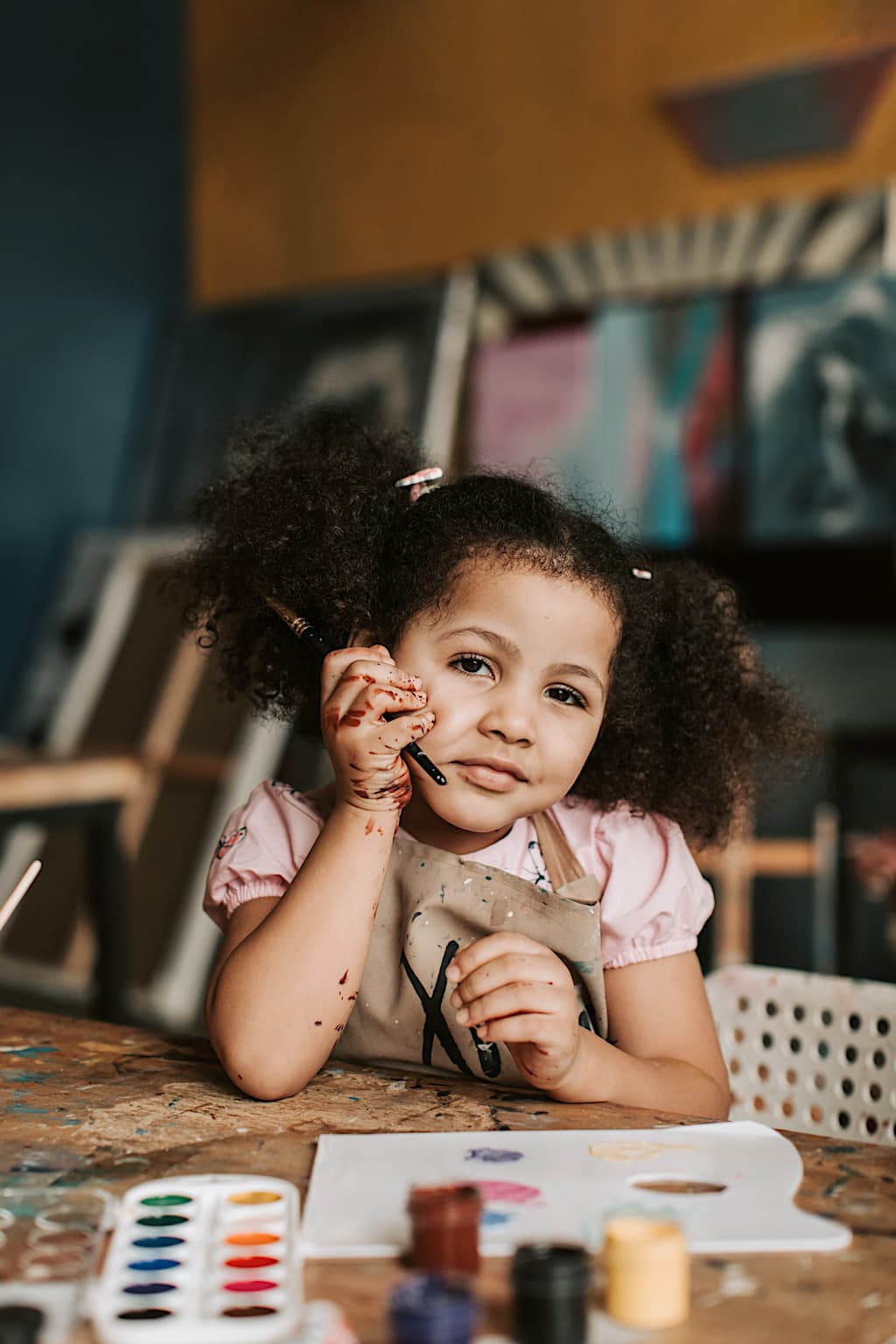 Vis et Deviens - un enfant assise sur une chaise ayant fait de la peinture.