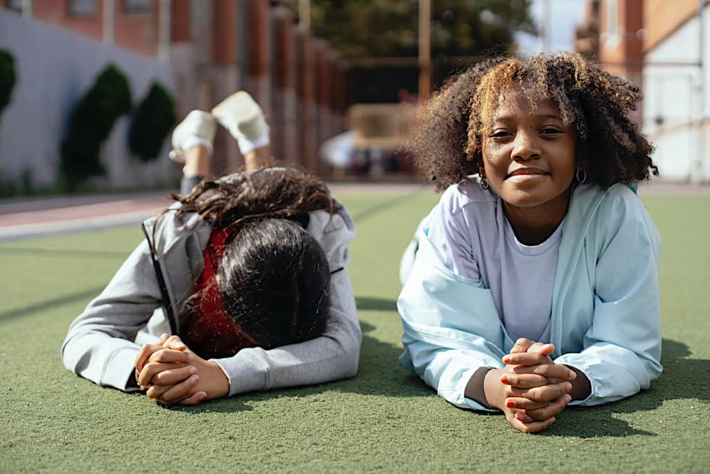 Vis et Deviens - deux filles souriantes sur un terrain de football