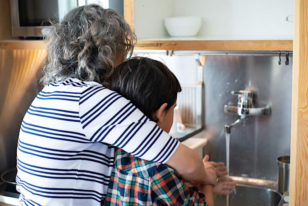 Vis et Deviens - une bénévole aidant un enfant à se laver les mains