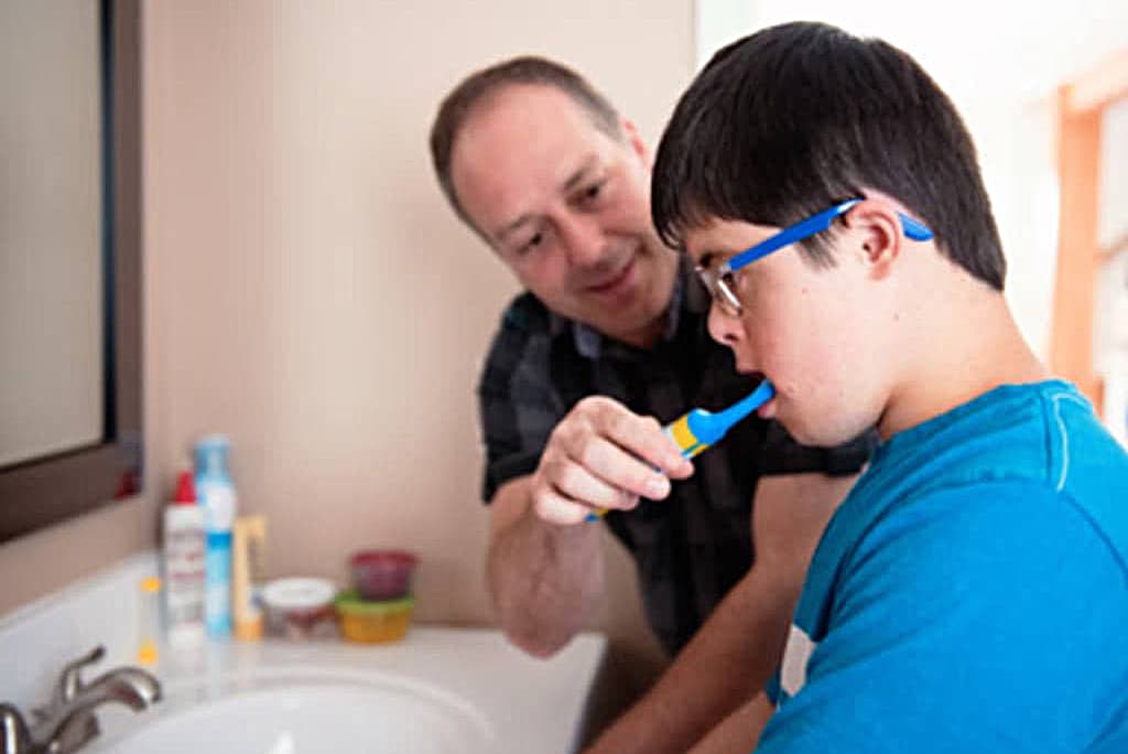 Vis et Deviens - Un père aidant son fils à se brosser les dents