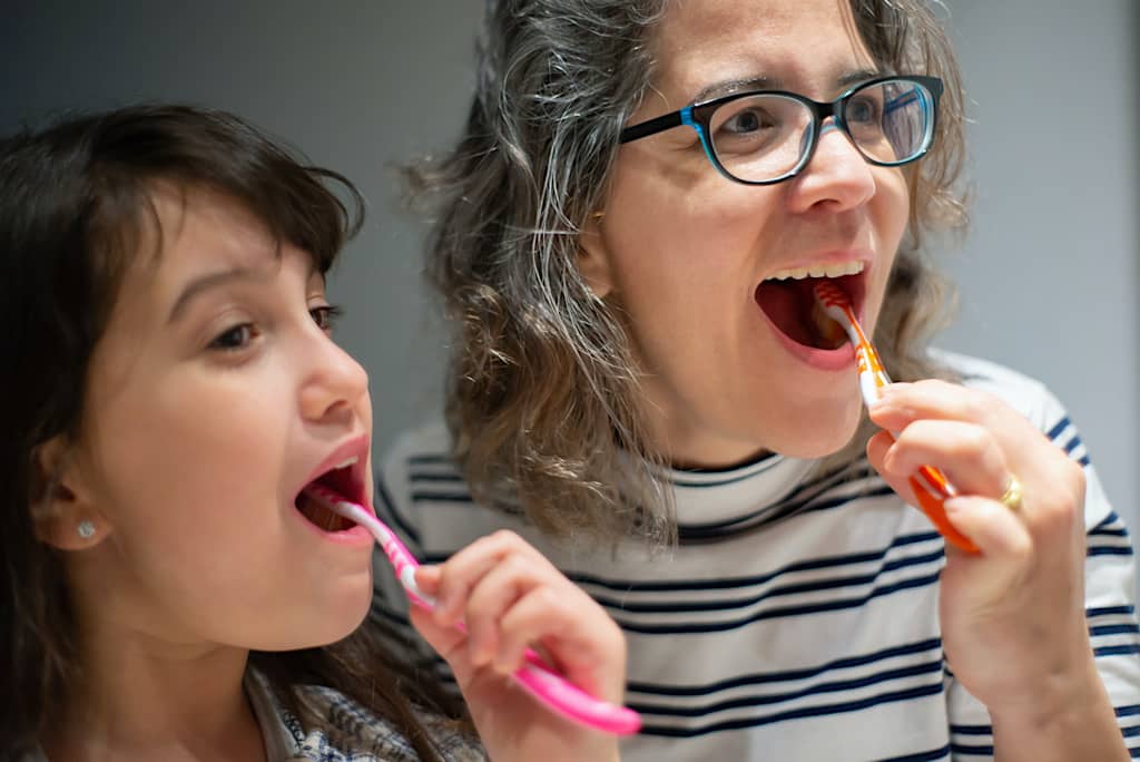 Vis et Deviens - un enfant brossant ces dents avec une bénévole